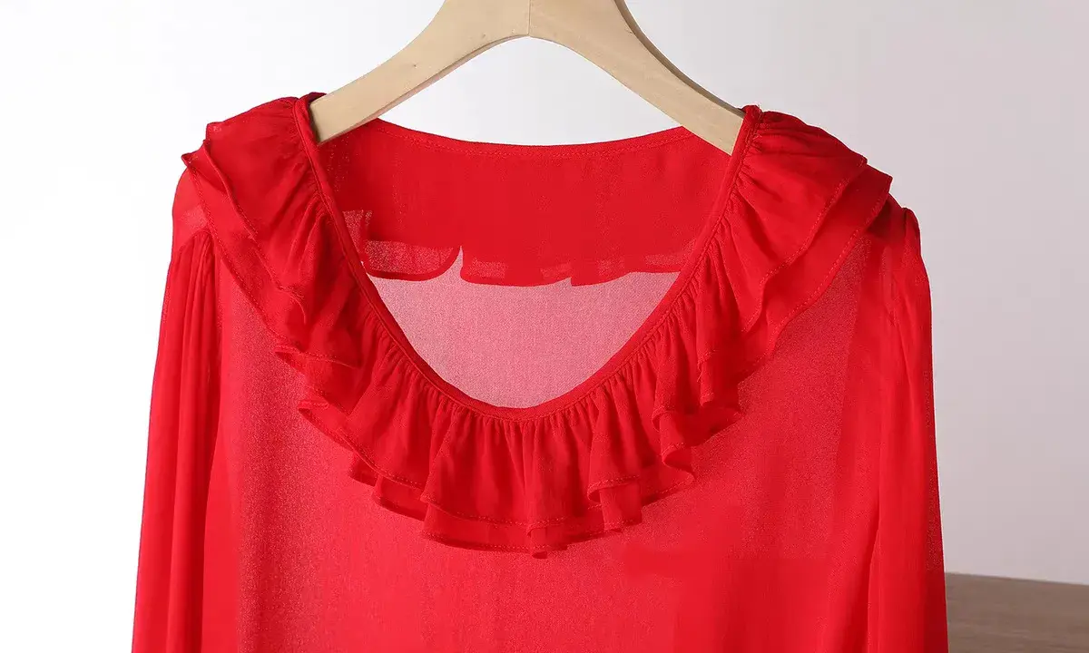 Blusa in chiffon rossa con ruches sul collo e sulle maniche. Un capo elegante e leggero.