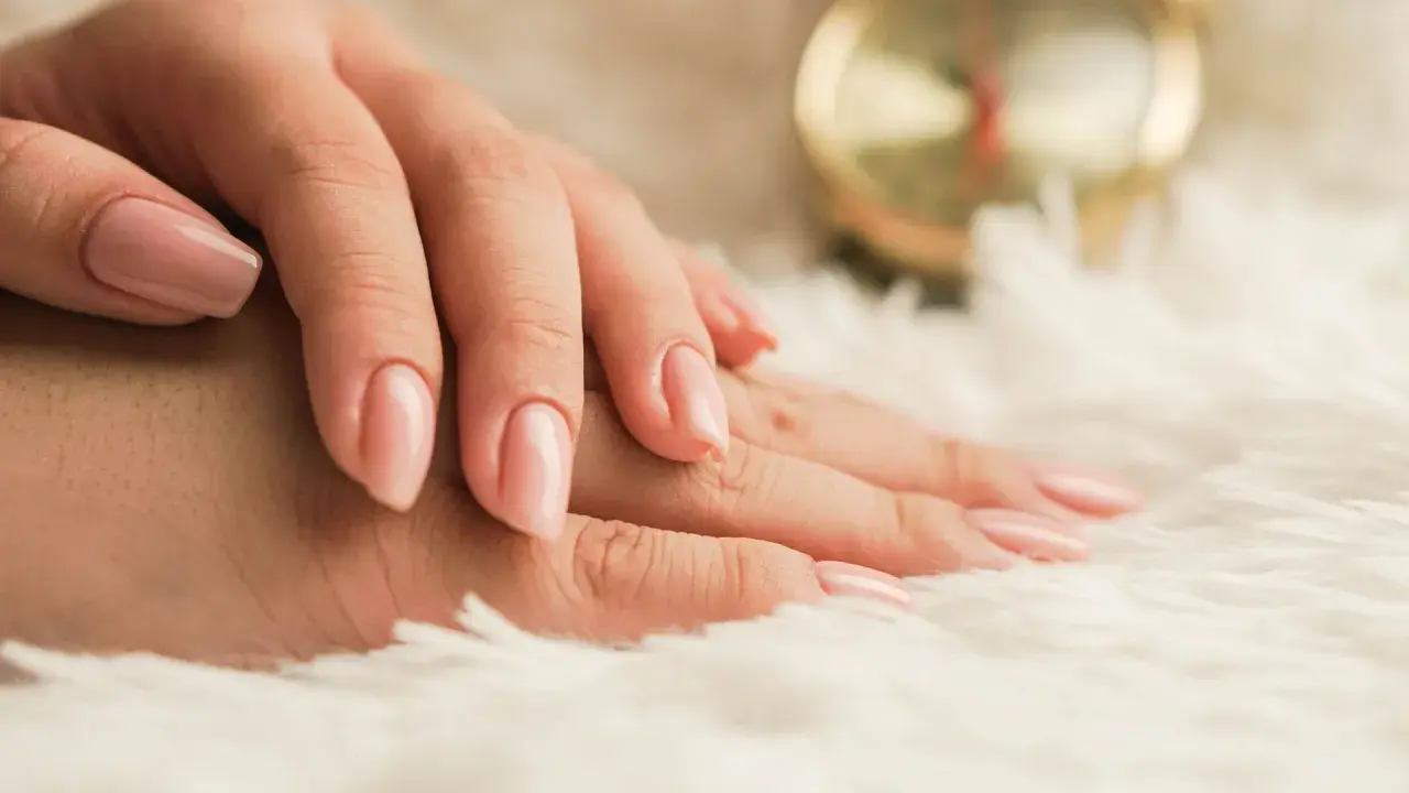 Mani curate con smalto rosa tenue, un esempio di come nutrire le unghie per una bellezza impeccabile.