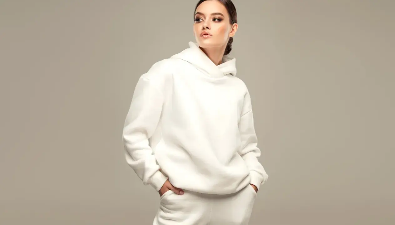 Modella con un'elegante felpa corta bianca, un look casual ma chic.