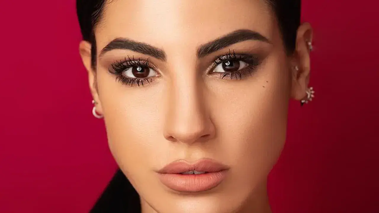 Volto di donna con trucco cerimonia semplice ed elegante: occhi scuri e labbra nude.
