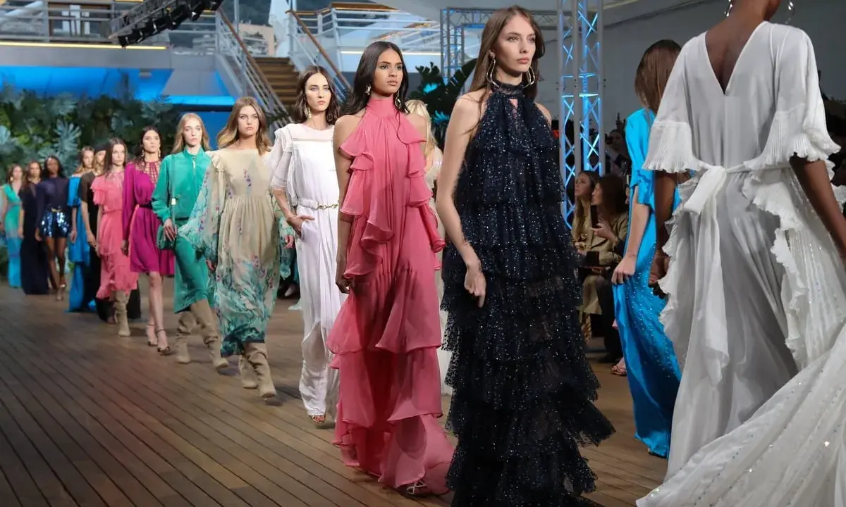 Sfilata di Alberta Ferretti con abiti corti e lunghi, in tessuti leggeri e colori vivaci, che danzano sulla passerella.
