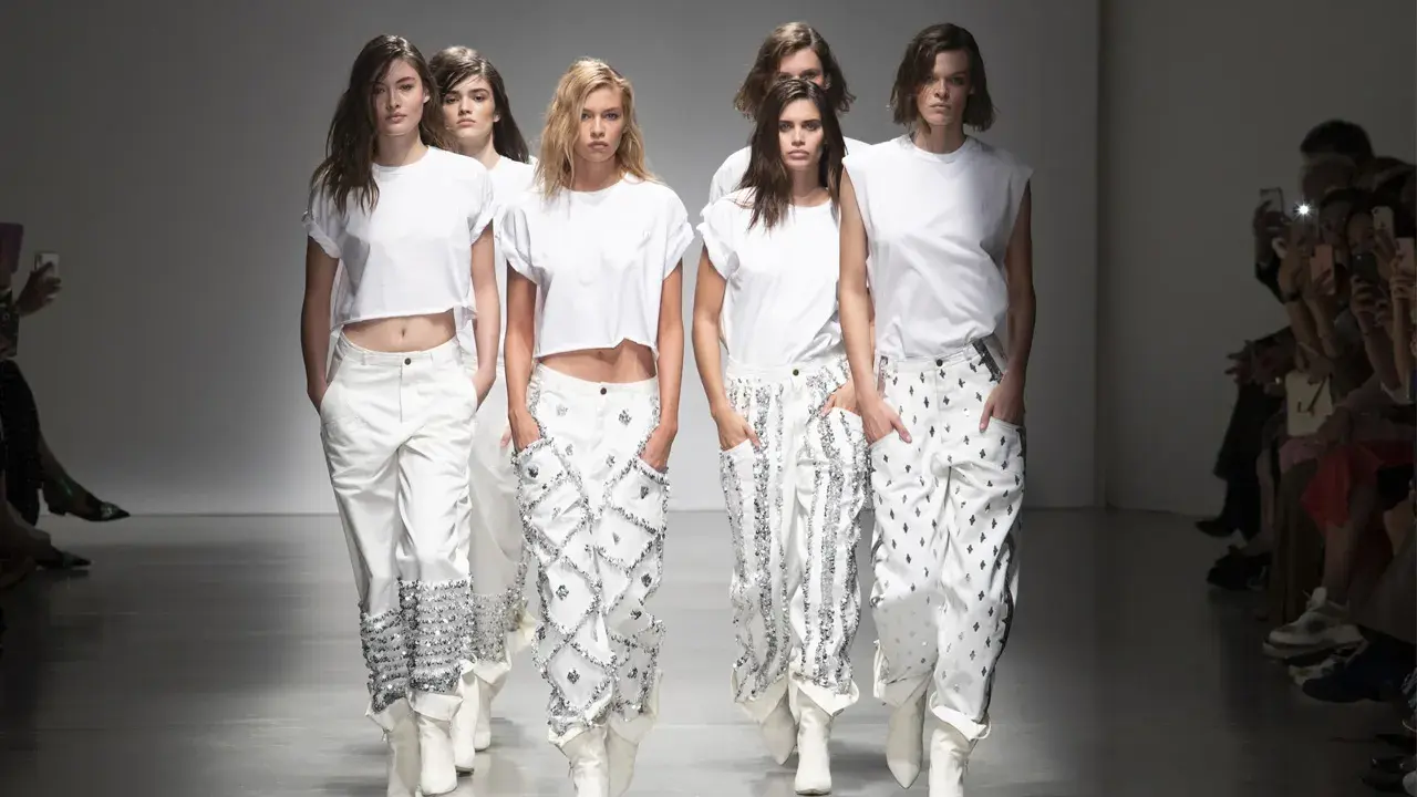 Sfilata Alberta Ferretti: abiti bianchi con dettagli scintillanti, un'espressione di filosofia minimalista e audace.