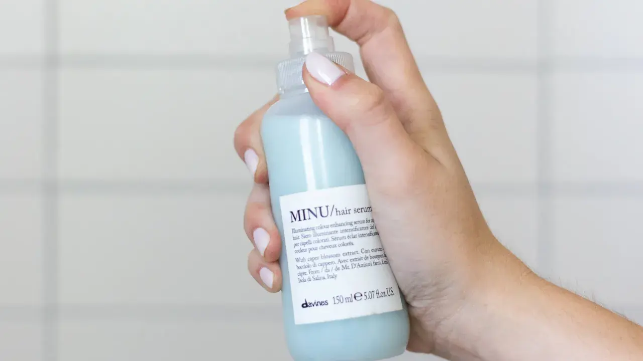 Mano che spruzza siero per capelli MINU. Ideale per capelli colorati, quando metterlo? Dopo lo shampoo, sui capelli tamponati.