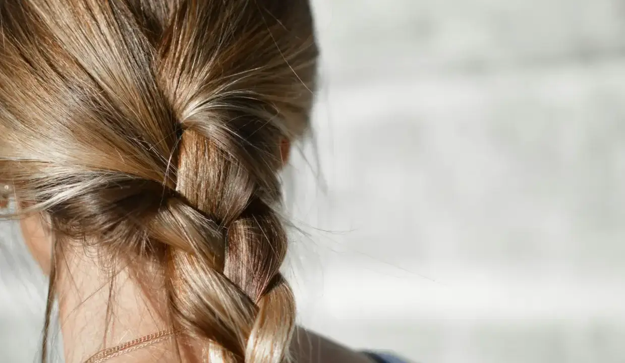 Capelli biondi intrecciati in una treccia. Per chi ha capelli grassi, la frequenza di lavaggio è una questione personale.