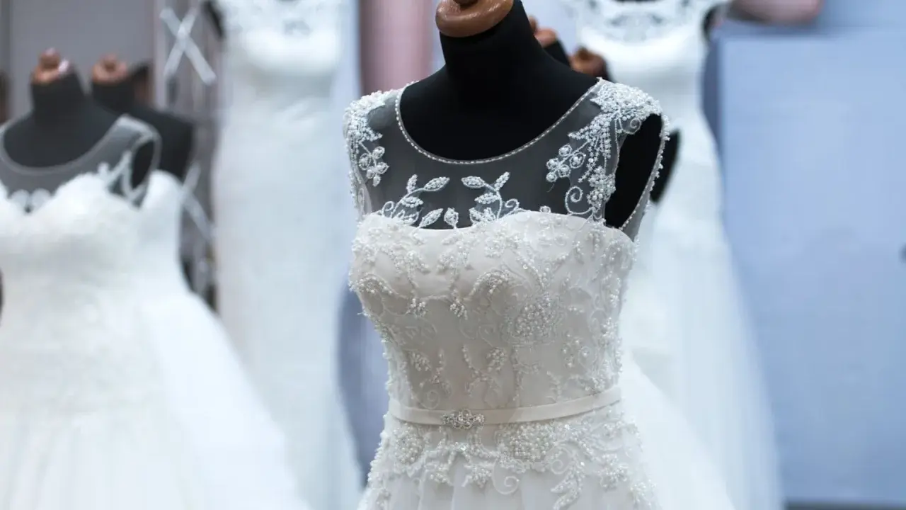 Abiti da sposa bianchi e ricamati su manichini, pronti per la donna che sogna il suo giorno speciale.