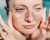Donna applica crema sul viso. Attenzione: crema solare tutti i giorni fa male alla pelle.