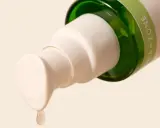 Goccia di gel di aloe vera da un flacone, ideale per lenire la dermatite seborroica.