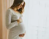 Donna incinta accarezza il pancione, pensando ai benefici dell'acido ialuronico in gravidanza per la pelle.