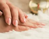 Mani curate con smalto rosa tenue, un esempio di come nutrire le unghie per una bellezza impeccabile.