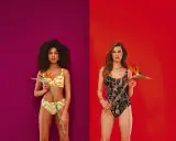 Due modelle con costumi Barrow, una in bikini giallo con fantasia tropicale, l'altra in costume intero nero con stampa floreale esotica.