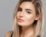 Volto di donna con capelli biondi e un make up naturale che esalta la sua bellezza.