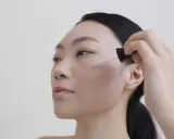 Donna applica siero viso. Per sapere niacinamide dopo quanto fa effetto, guarda la sua pelle luminosa.