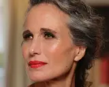 Donna con capelli grigi e trucco impeccabile, labbra rosse vivaci. Un esempio di come truccarsi a 50 anni con eleganza.