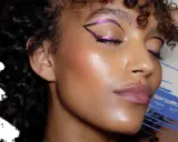 Occhi magnetici con eyeliner fucsia glitterato, labbra nude e pelle luminosa. Un trucco per more che esalta la bellezza naturale.