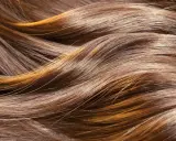 Capelli castani con riflessi dorati, dall'aspetto secco e opaco, come capelli rovinati dopo trattamento cheratina.