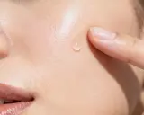 Goccia di siero sulla pelle, un tocco delicato. La niacinamide a cosa serve? Migliora la barriera cutanea e riduce le imperfezioni.