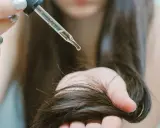 Goccia di olio di ricino su capelli scuri. Scopri a cosa serve l'olio di ricino per la cura dei capelli e della pelle.