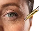 Goccia di siero al retinolo vicino all'occhio per combattere le rughe. Scopri come usarlo per una pelle più giovane.