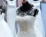 Abiti da sposa bianchi e ricamati su manichini, pronti per la donna che sogna il suo giorno speciale.
