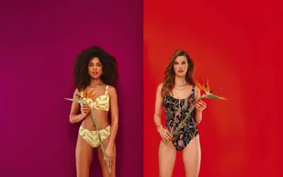 Due modelle con costumi Barrow, una in bikini giallo con fantasia tropicale, l'altra in costume intero nero con stampa floreale esotica.