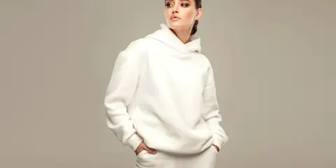 Modella con un'elegante felpa corta bianca, un look casual ma chic.