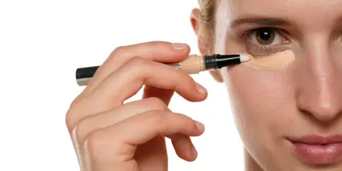 Applicazione di correttore sotto l'occhio, un passo essenziale per chi vuole sapere come togliere trucco waterproof e avere un incarnato perfetto.