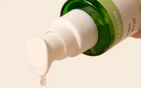 Goccia di gel di aloe vera da un flacone, ideale per lenire la dermatite seborroica.
