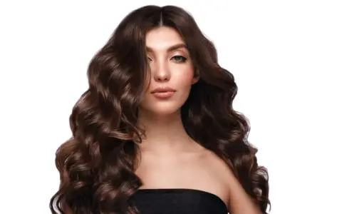 Capelli castani, lunghi e ondulati, morbidi e lucenti grazie al segreto di lasciare il balsamo sui capelli tutta la notte.