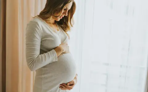 Donna incinta accarezza il pancione, pensando ai benefici dell'acido ialuronico in gravidanza per la pelle.