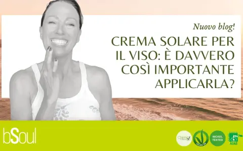 Donna sorridente applica crema sul viso. Il blog parla di crema solare per il viso: è davvero importante usarla come crema idratante?