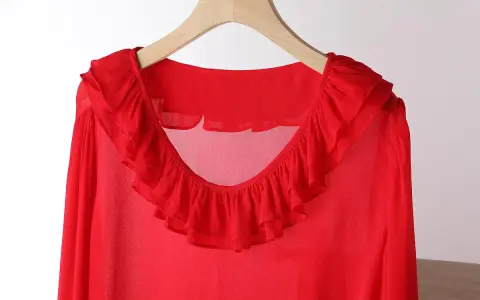 Blusa in chiffon rossa con ruches sul collo e sulle maniche. Un capo elegante e leggero.