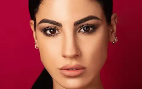 Volto di donna con trucco cerimonia semplice ed elegante: occhi scuri e labbra nude.