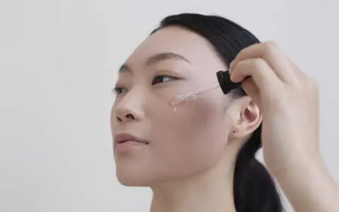 Donna applica siero viso. Per sapere niacinamide dopo quanto fa effetto, guarda la sua pelle luminosa.