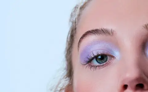 Occhio con ombretto lilla scintillante, ciglia lunghe e sopracciglia definite. Un trucco per serata elegante che cattura lo sguardo.