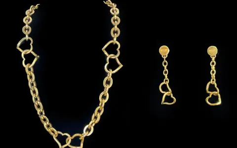 Collana Moschino in oro con cuori intrecciati e orecchini pendenti coordinati.