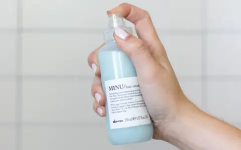 Mano che spruzza siero per capelli MINU. Ideale per capelli colorati, quando metterlo? Dopo lo shampoo, sui capelli tamponati.
