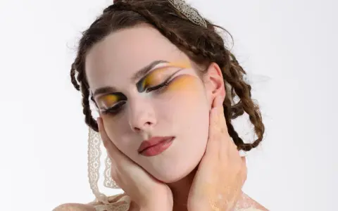 Modella con trucco artistico audace, occhi colorati e dettagli dorati. Idee trucco artistico per un look da sogno.