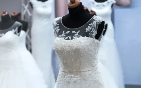 Abiti da sposa bianchi e ricamati su manichini, pronti per la donna che sogna il suo giorno speciale.