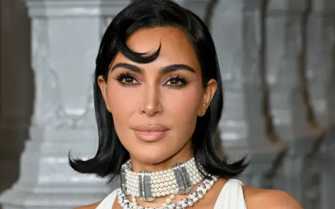 Kim Kardashian con un look sofisticato, evidenziando la tecnica del "baking" per un incarnato impeccabile.