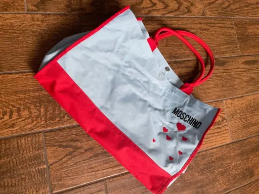 Shopper Moschino azzurro e rosso con cuoricini. Perfetta per portare con te un tocco di stile.