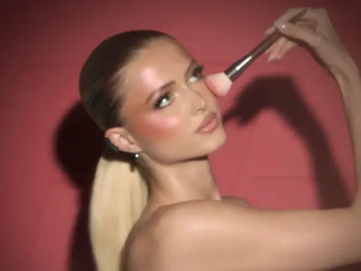 Donna bionda con un pennello applica il blush in polvere sulle guance per un look radioso.