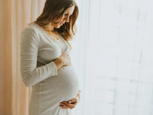 Donna incinta accarezza il pancione, pensando ai benefici dell'acido ialuronico in gravidanza per la pelle.
