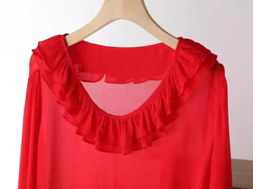 Blusa in chiffon rossa con ruches sul collo e sulle maniche. Un capo elegante e leggero.