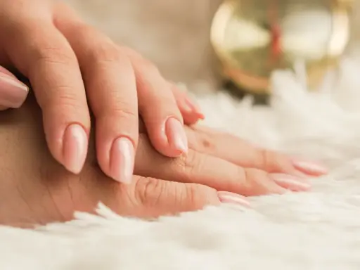 Mani curate con smalto rosa tenue, un esempio di come nutrire le unghie per una bellezza impeccabile.