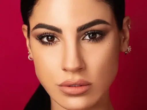 Volto di donna con trucco cerimonia semplice ed elegante: occhi scuri e labbra nude.