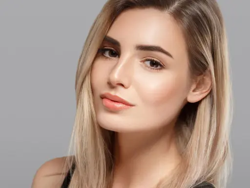 Volto di donna con capelli biondi e un make up naturale che esalta la sua bellezza.