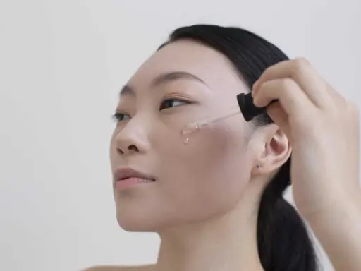 Donna applica siero viso. Per sapere niacinamide dopo quanto fa effetto, guarda la sua pelle luminosa.