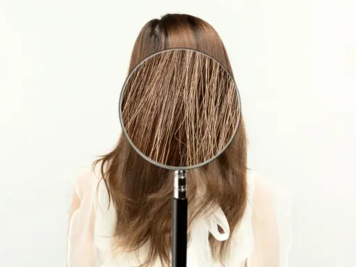 Ingrandimento dei capelli sfibrati, mostrando le cause di fragilità e secchezza.