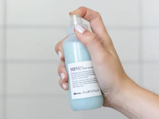 Mano che spruzza siero per capelli MINU. Ideale per capelli colorati, quando metterlo? Dopo lo shampoo, sui capelli tamponati.