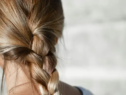 Capelli biondi intrecciati in una treccia. Per chi ha capelli grassi, la frequenza di lavaggio è una questione personale.